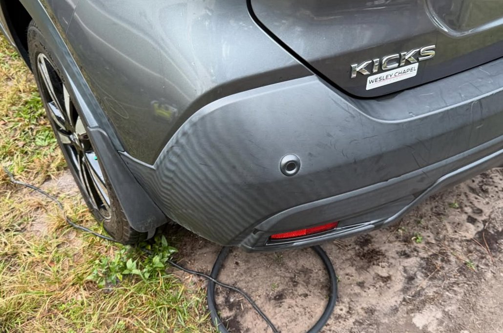 Before: dull, streaky gray trim on the rear bumper of a Nissan Kicks