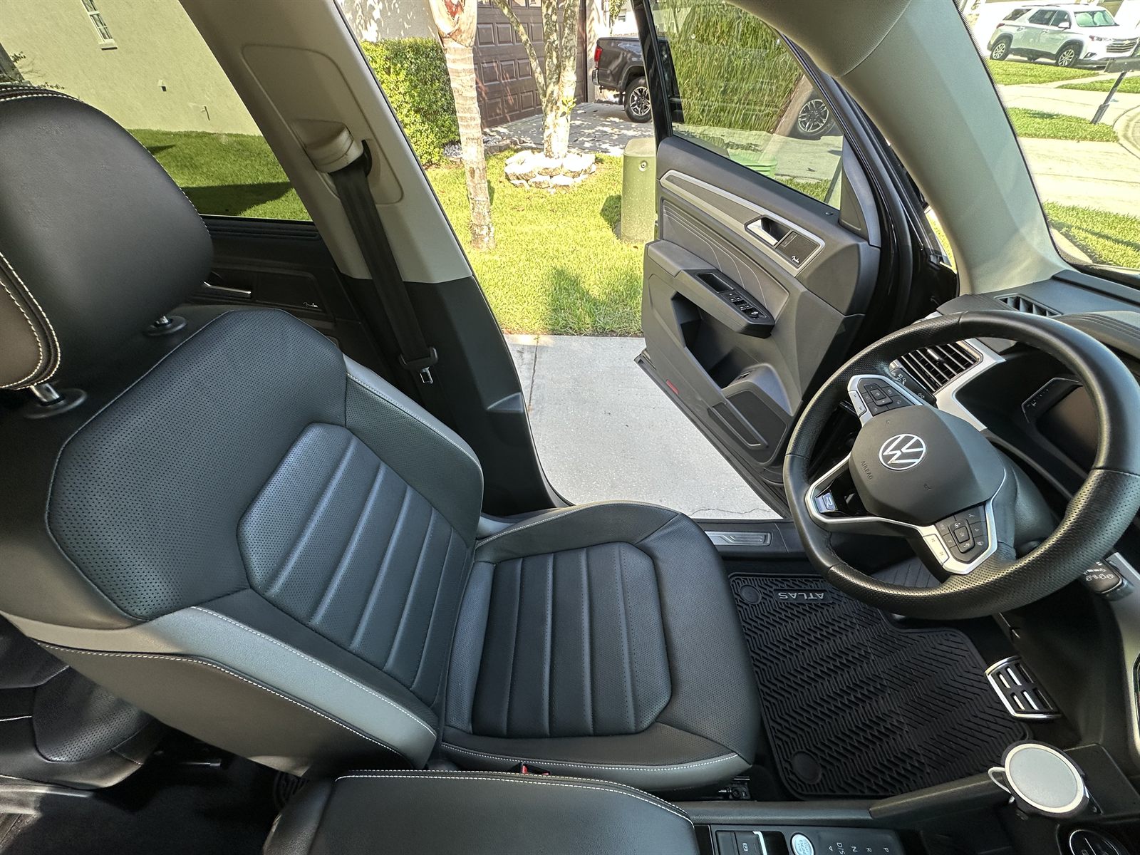 Spotless leather seat, steering wheel and floor mat inside a VW Atlas after an interior detail